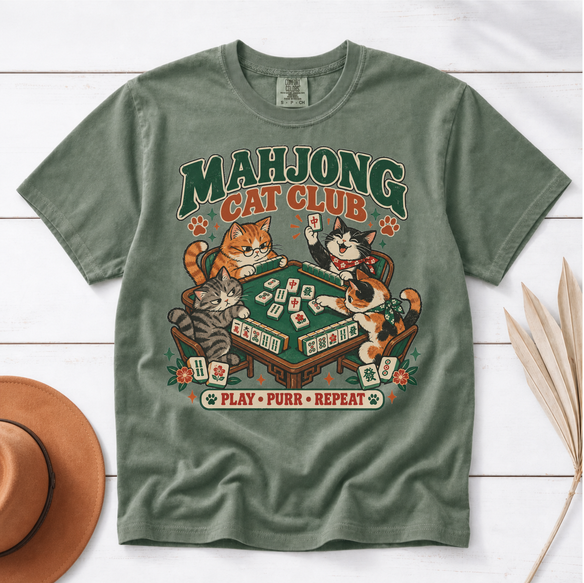Mahjong Cat Club t-shirt in Jean Blue, flat lay on white wood