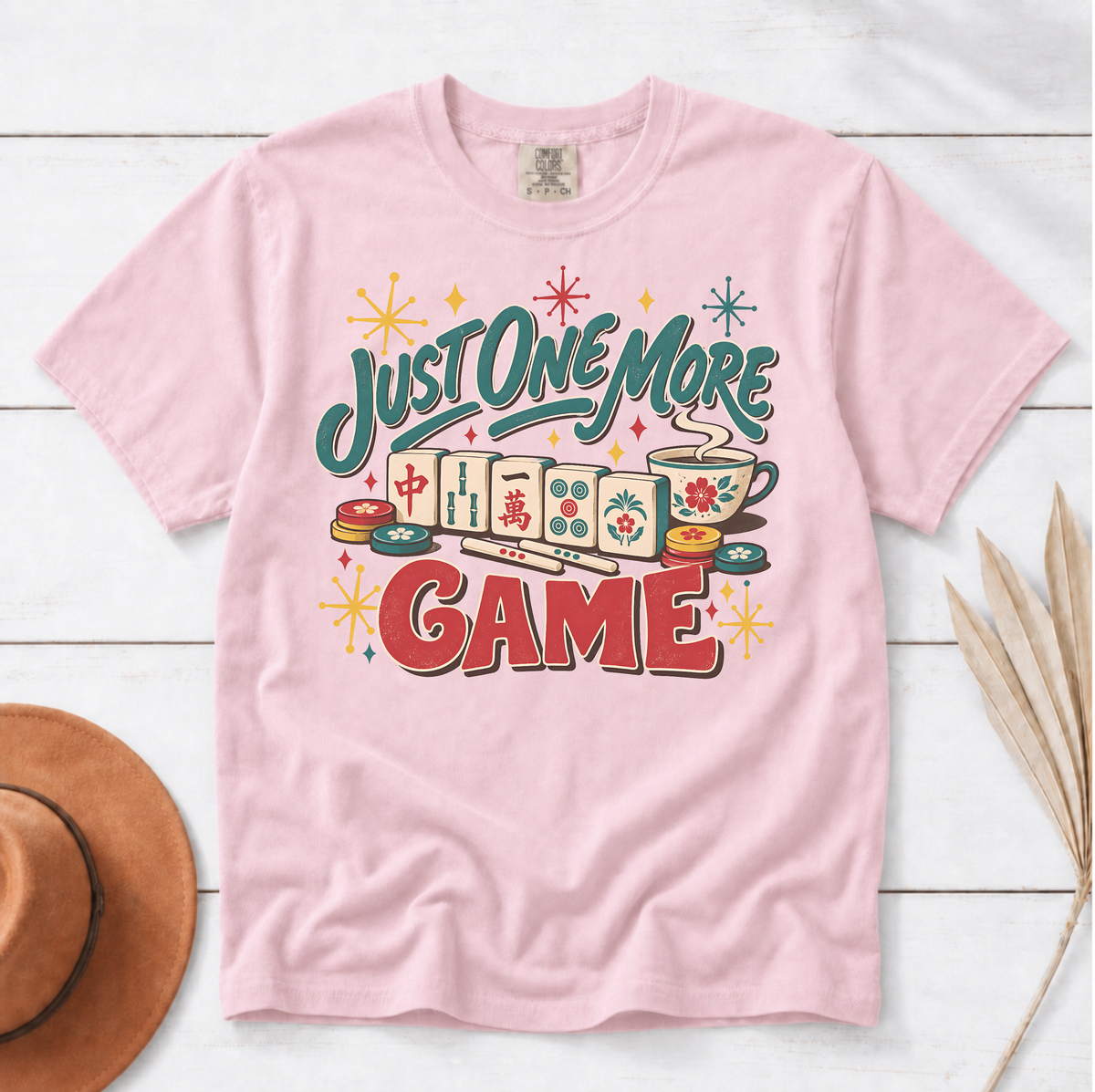 Just One More Game mahjong t-shirt in Ivory, folded mockup on white wood