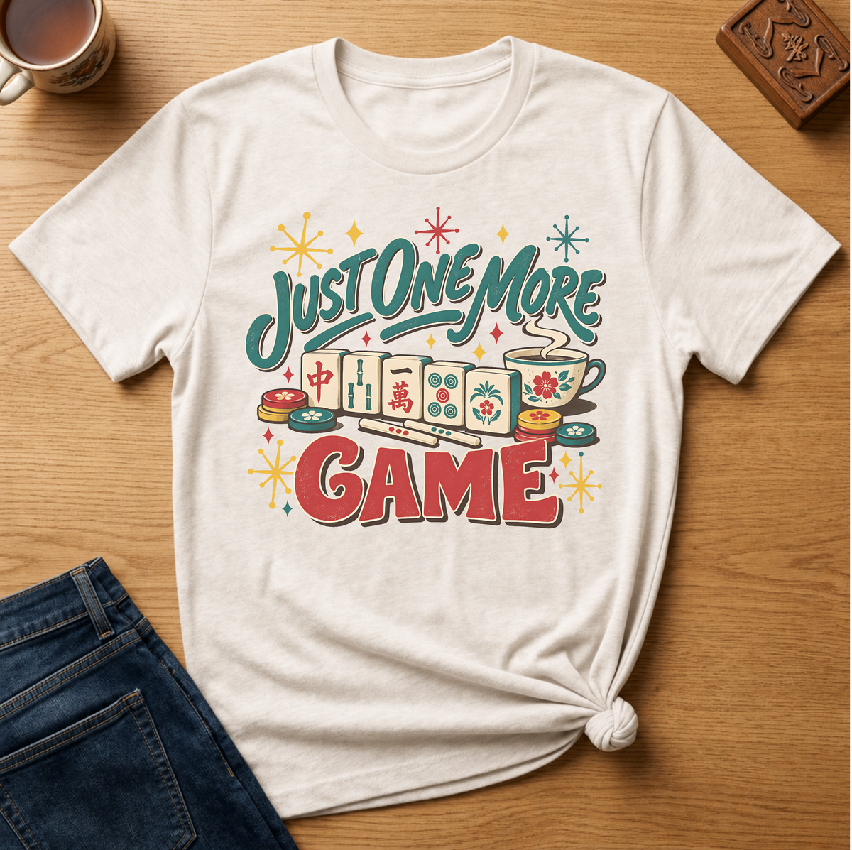 Just One More Game mahjong t-shirt in Ivory, flat lay on white wood