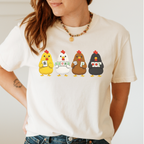 Mahjong Chickens Shirt in Ivory - four cartoon hens holding mahjong tiles on an ivory Comfort Colors 1717 tee, flat lay