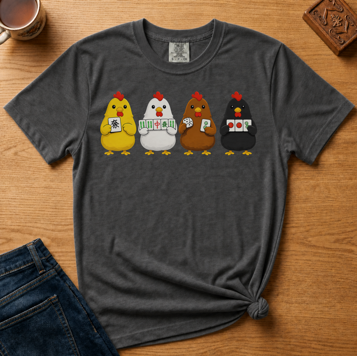 Mahjong Chickens Shirt in Espresso - four cartoon hens holding mahjong tiles on a brown Comfort Colors 1717 tee, flat lay