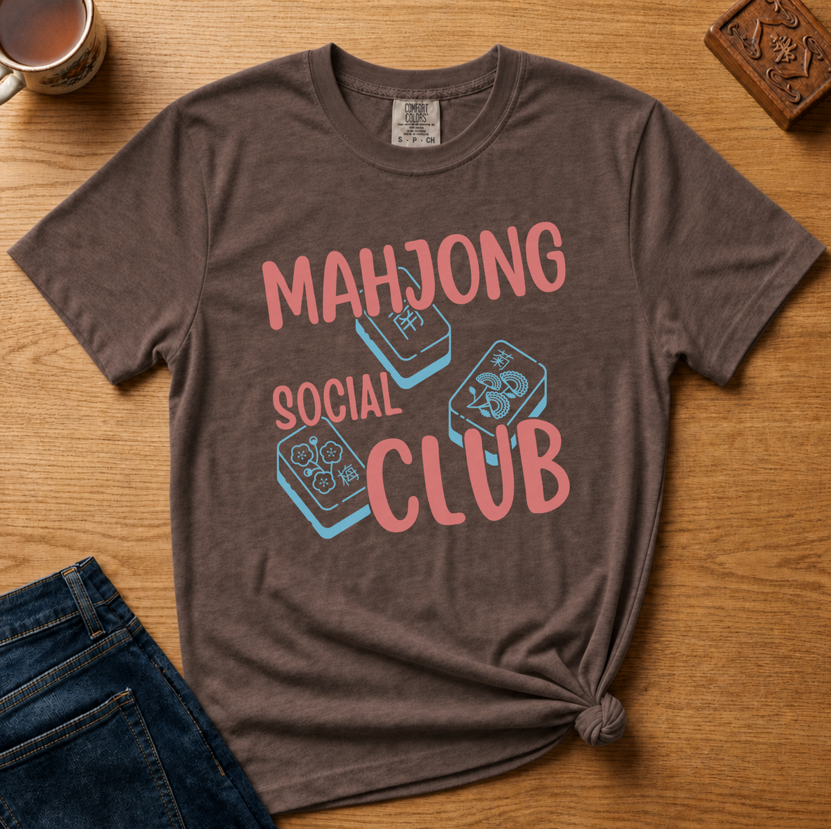 Mahjong Social Club Shirt in Black - MAHJONG SOCIAL CLUB typographic tile design on a black Comfort Colors 1717 tee, flat lay