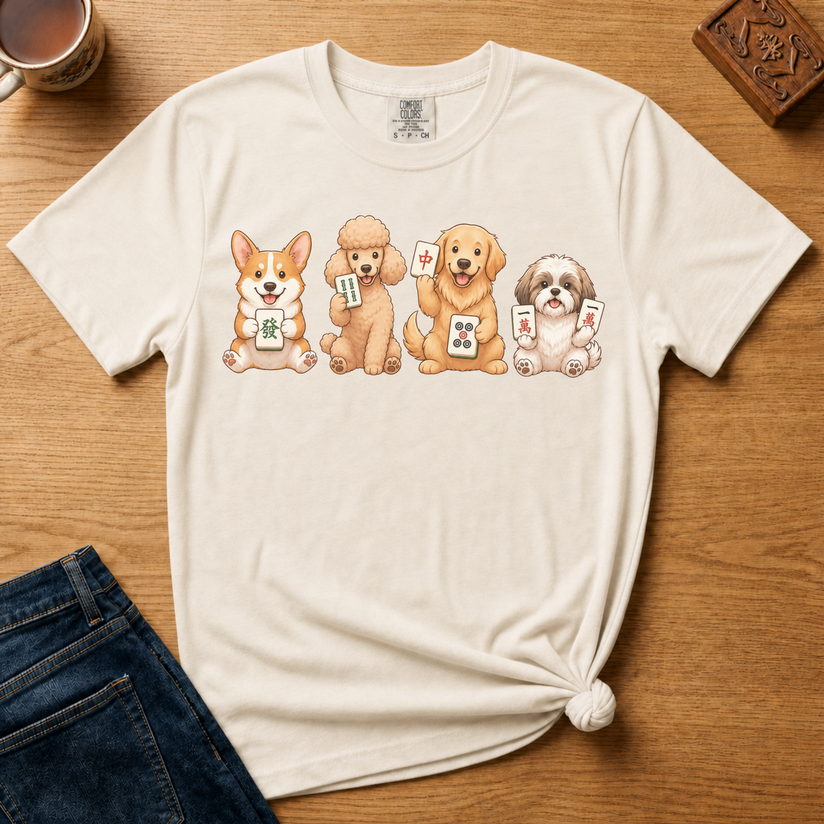 Mahjong Dogs Shirt in Pepper - four cartoon dogs holding mahjong tiles on a dark grey Comfort Colors 1717 tee, flat lay