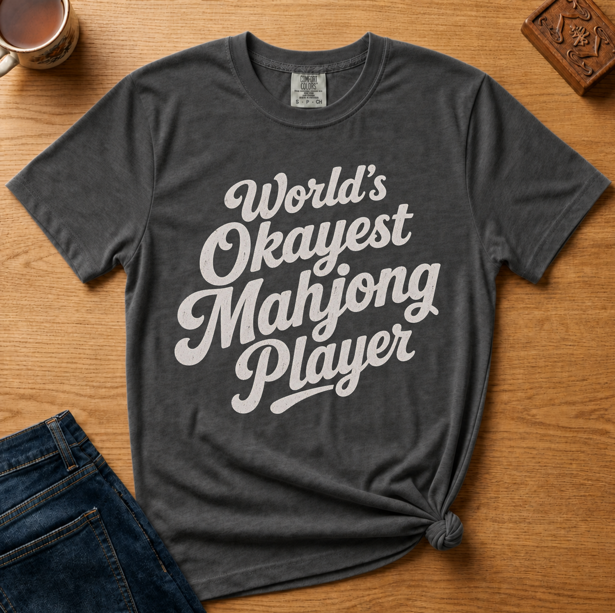 World's Okayest Mahjong Player Shirt in Berry - retro cream script on a berry Comfort Colors 1717 tee, flat lay