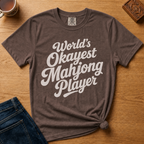 World's Okayest Mahjong Player Shirt in Espresso - retro cream script on a brown Comfort Colors 1717 tee, flat lay
