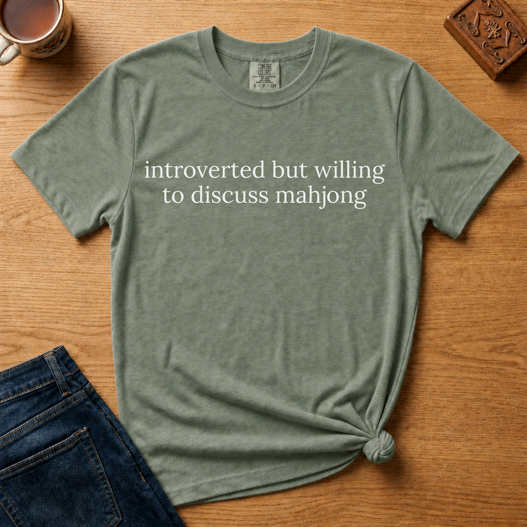 Introverted But Willing To Discuss Mahjong Shirt in Moss - cream serif text on a green Comfort Colors 1717 tee, flat lay