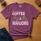 She Runs On Coffee And Mahjong Shirt in Espresso - pink bubble lettering with coffee cup and tile doodles on a brown Comfort Colors 1717 tee, flat lay
