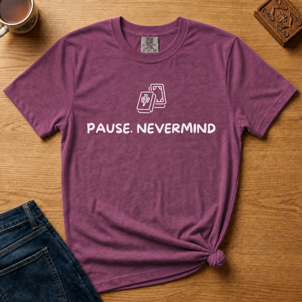 Pause Nevermind Tile Shirt in Berry - line-art mahjong tile with PAUSE. NEVERMIND text on a berry Comfort Colors 1717 tee, flat lay