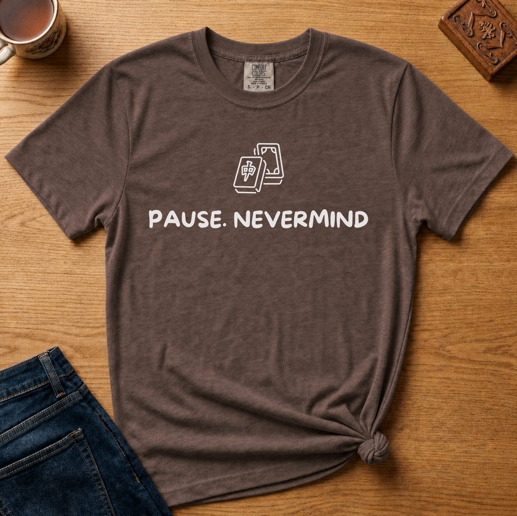 Pause Nevermind Tile Shirt in Espresso - line-art mahjong tile with PAUSE. NEVERMIND text on a brown Comfort Colors 1717 tee, flat lay