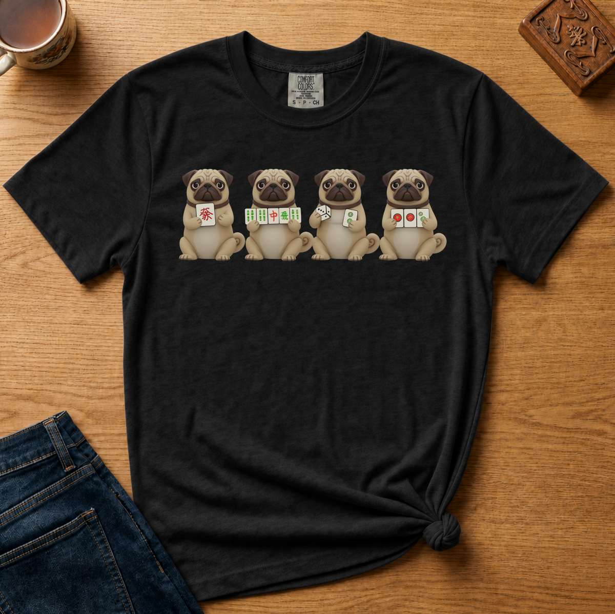 Mahjong Pugs Shirt in Espresso - four cartoon pugs holding mahjong tiles on a brown Comfort Colors 1717 tee, flat lay