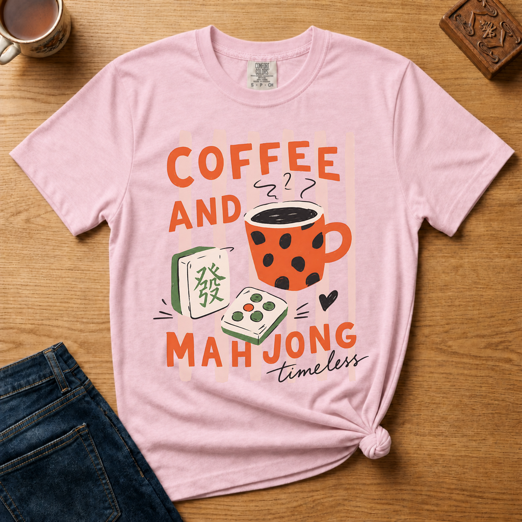 Striped Coffee and Mahjong Shirt in White - orange lettering with polka-dot mug and tiles over pink stripes on a white Comfort Colors 1717 tee, flat lay