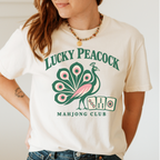 Lucky Peacock Mahjong Shirt in Violet - green and pink peacock with mahjong tiles on a lavender Comfort Colors 1717 tee, flat lay