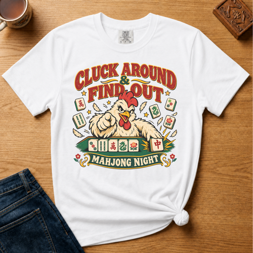 Cluck Around And Find Out Shirt in Black - fierce cartoon chicken behind a mahjong tile rack on a black Comfort Colors 1717 tee, flat lay