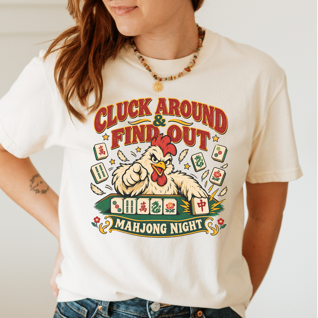Cluck Around And Find Out Shirt in Ivory - fierce cartoon chicken behind a mahjong tile rack on an ivory Comfort Colors 1717 tee, flat lay