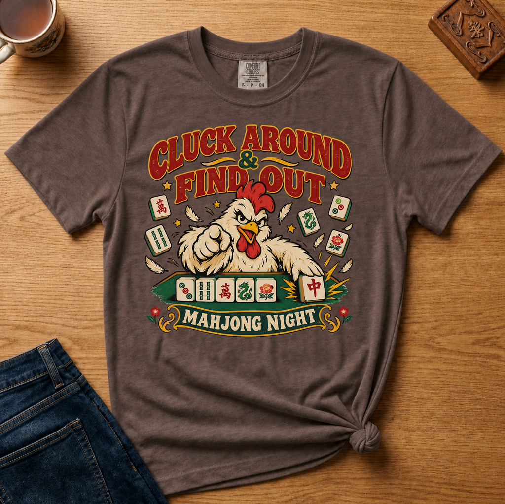 Cluck Around And Find Out Shirt in White - fierce cartoon chicken behind a mahjong tile rack on a white Comfort Colors 1717 tee, flat lay