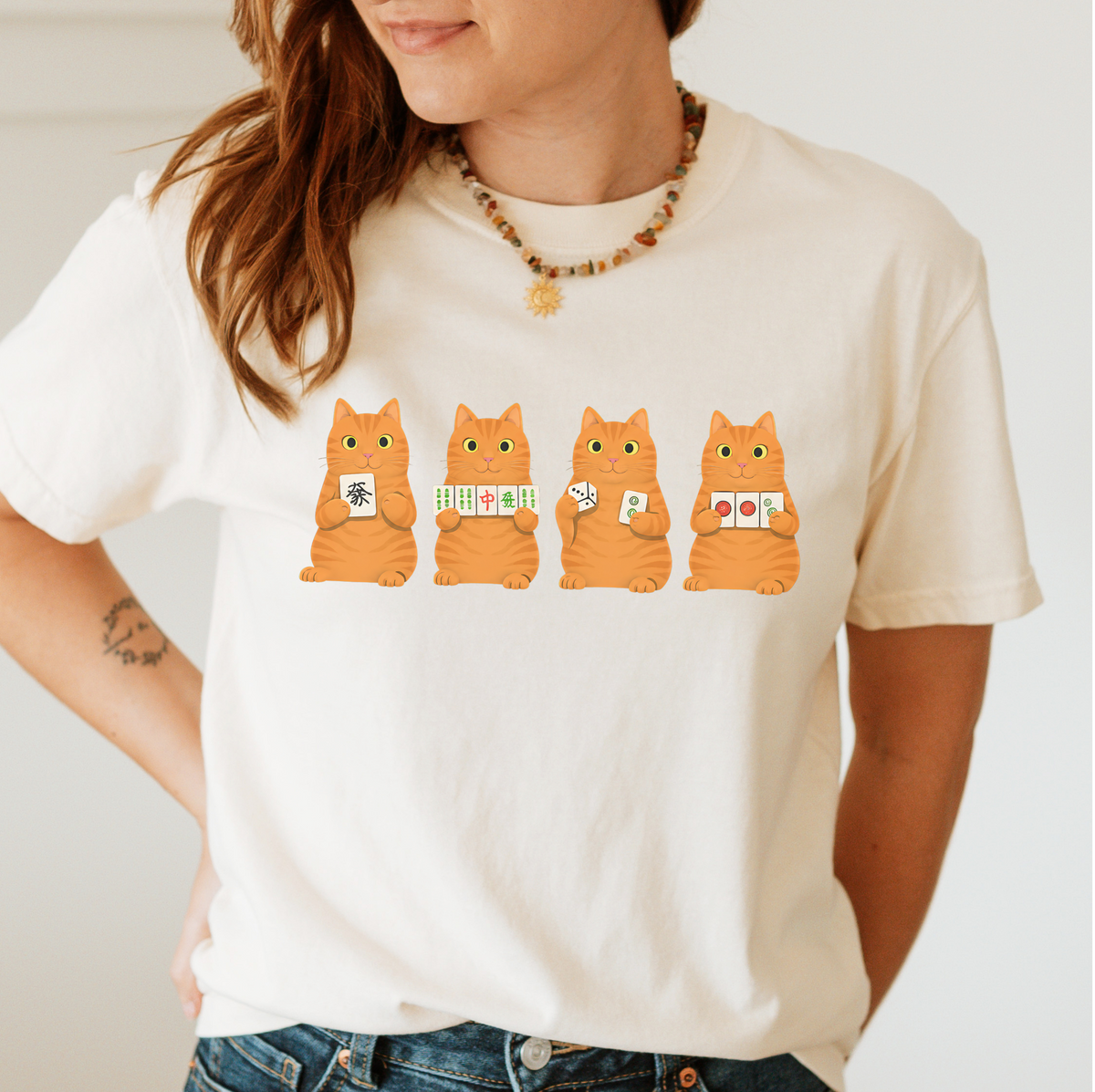 Mahjong Orange Tabby Cats Shirt in Pepper - four orange tabby cats holding mahjong tiles on a dark grey Comfort Colors 1717 tee, flat lay