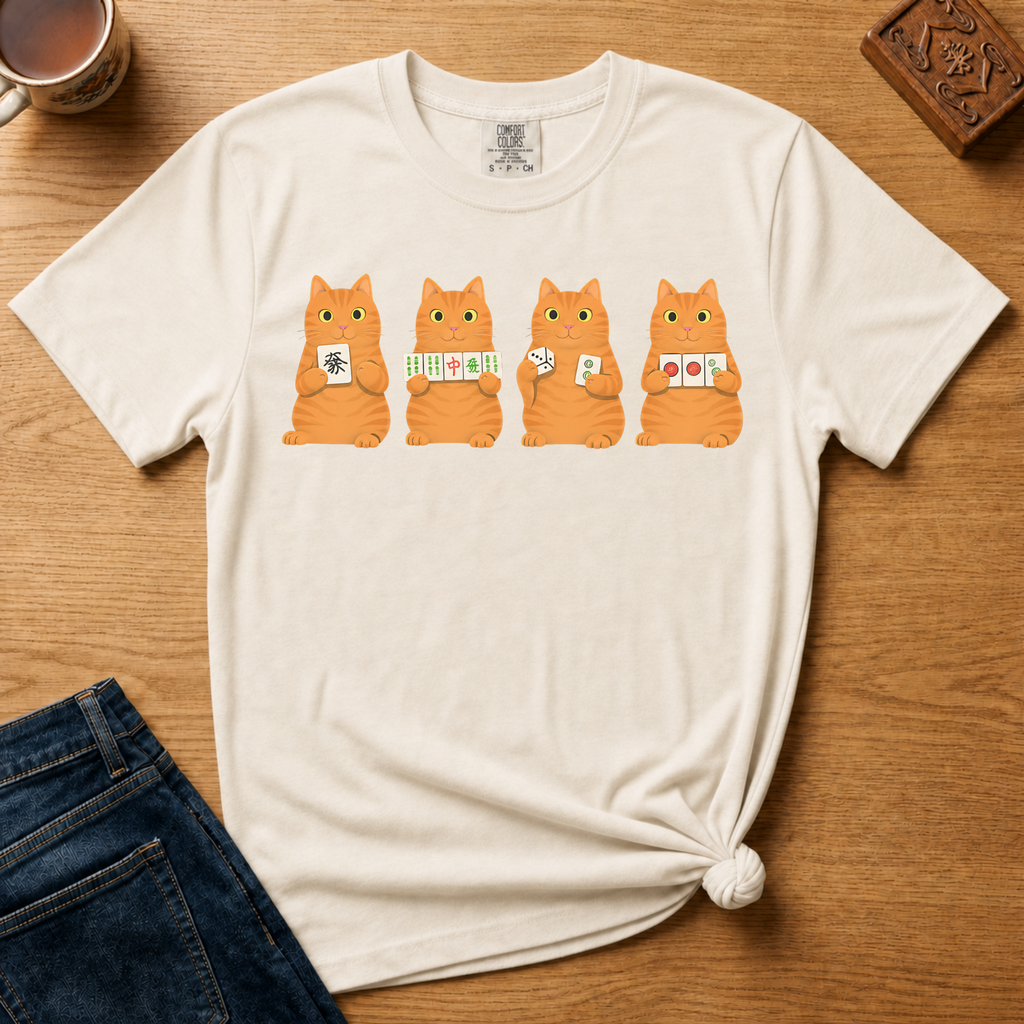 Mahjong Orange Tabby Cats Shirt in Blossom - four orange tabby cats holding mahjong tiles on a pink Comfort Colors 1717 tee, flat lay