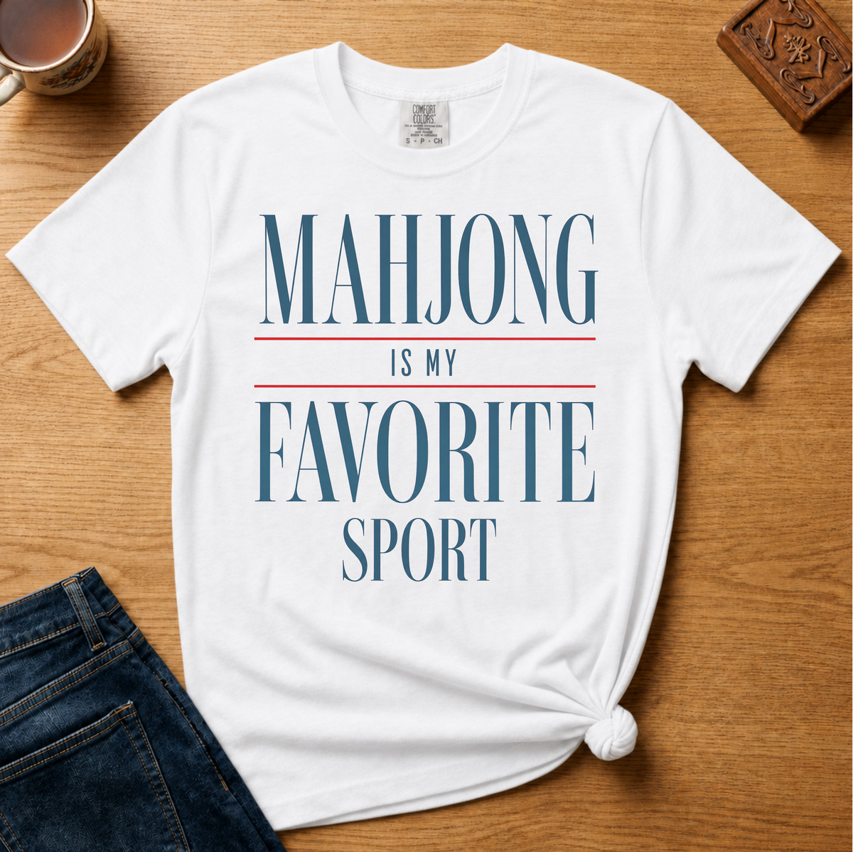 Mahjong Is My Favorite Sport Shirt in Blossom - navy serif lettering with red divider lines on a pink Comfort Colors 1717 tee, flat lay