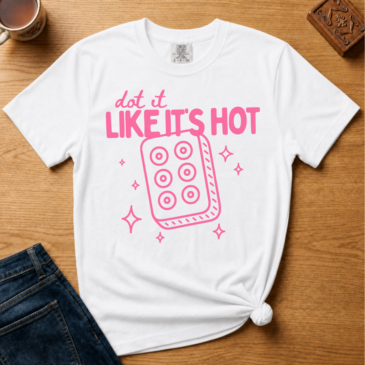 Dot It Like It's Hot Shirt in Black - pink dot it like it's hot lettering with a six-dot tile on a black Comfort Colors 1717 tee, flat lay