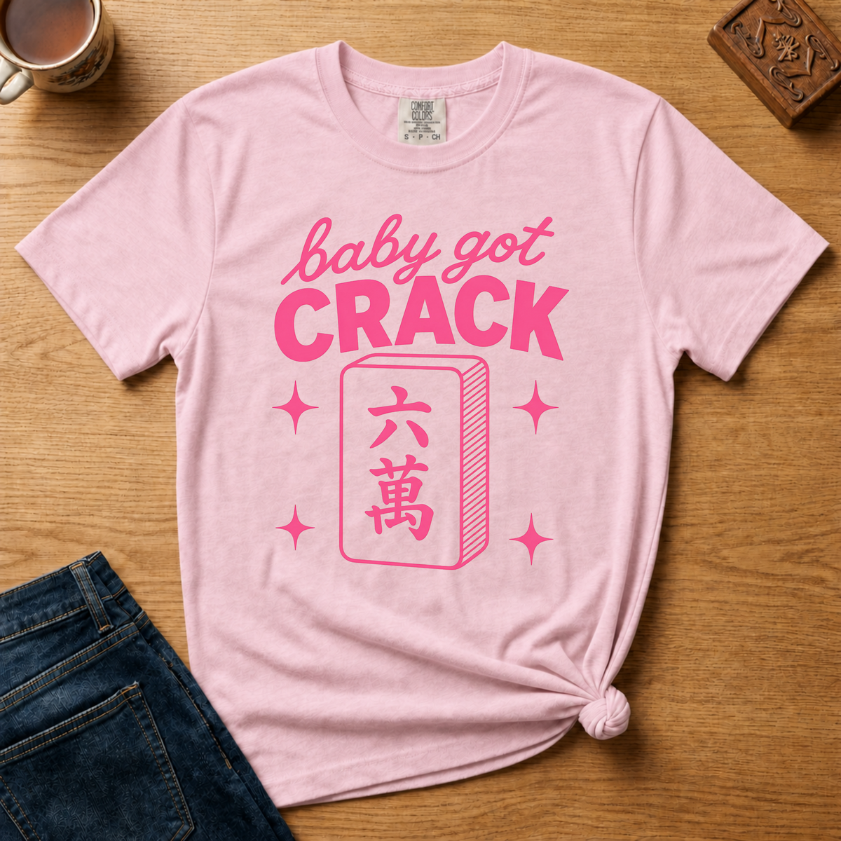 Baby Got Crack Shirt in Blossom - pink baby got crack lettering with a six-crack tile on a light pink Comfort Colors 1717 tee, flat lay