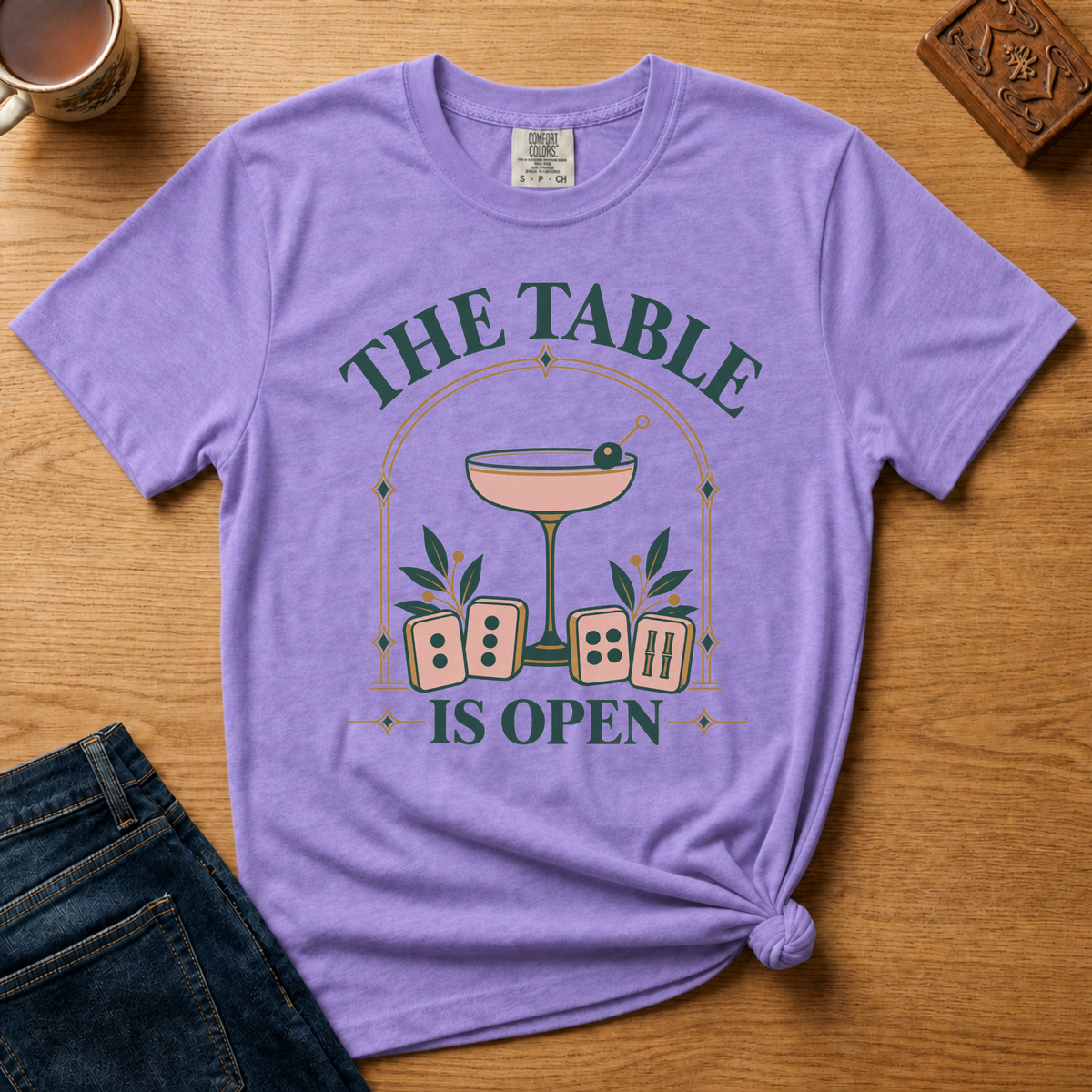 The Table Is Open Shirt in White - close-up of the cocktail coupe, peach tiles and THE TABLE IS OPEN lettering