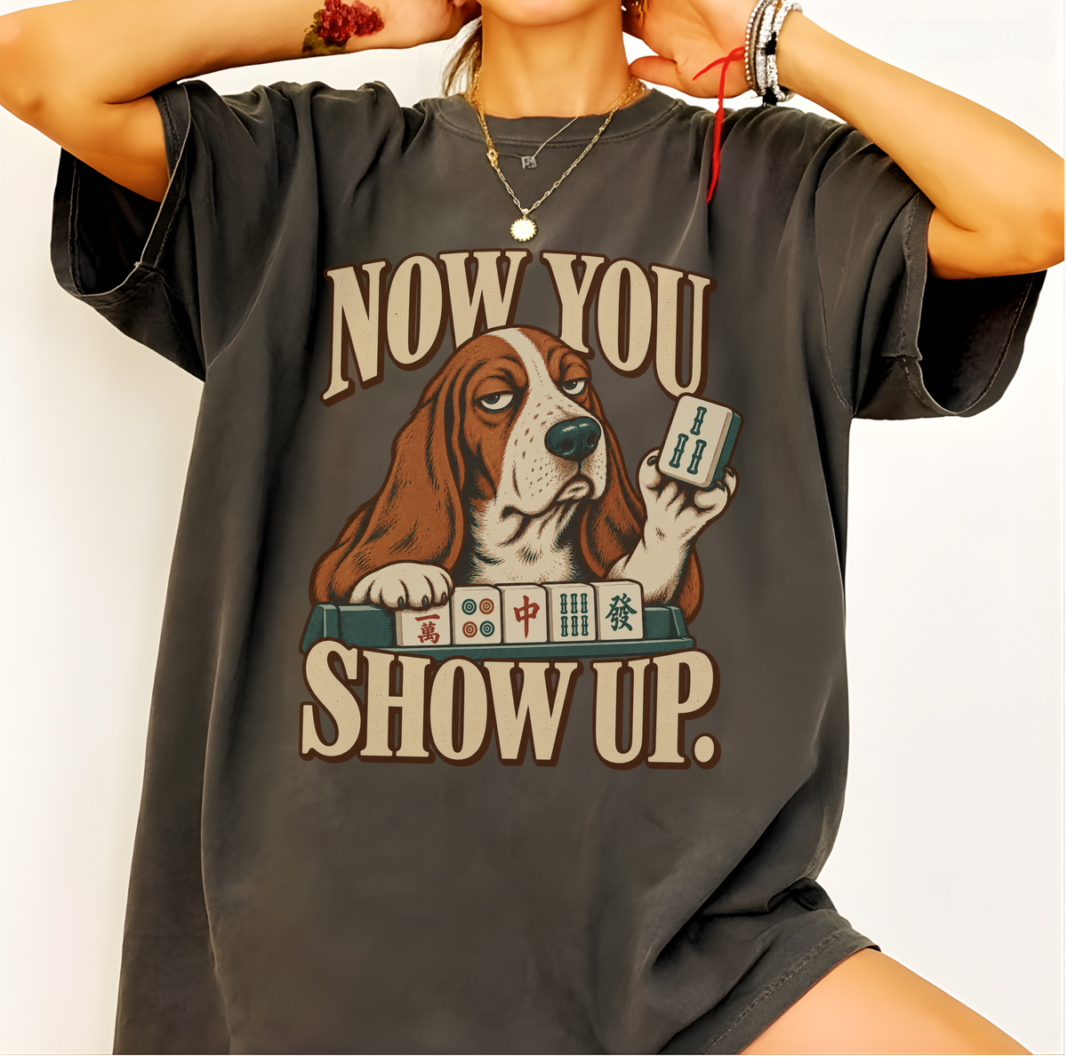 Now You Show Up basset hound mahjong shirt in Espresso, styled flat lay on a wooden table with jeans and coffee.