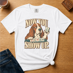 Close-up of the Now You Show Up basset hound design on a Moss Comfort Colors t-shirt.