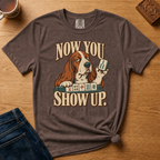 Close-up of the Now You Show Up basset hound design on a Jean Blue Comfort Colors t-shirt.