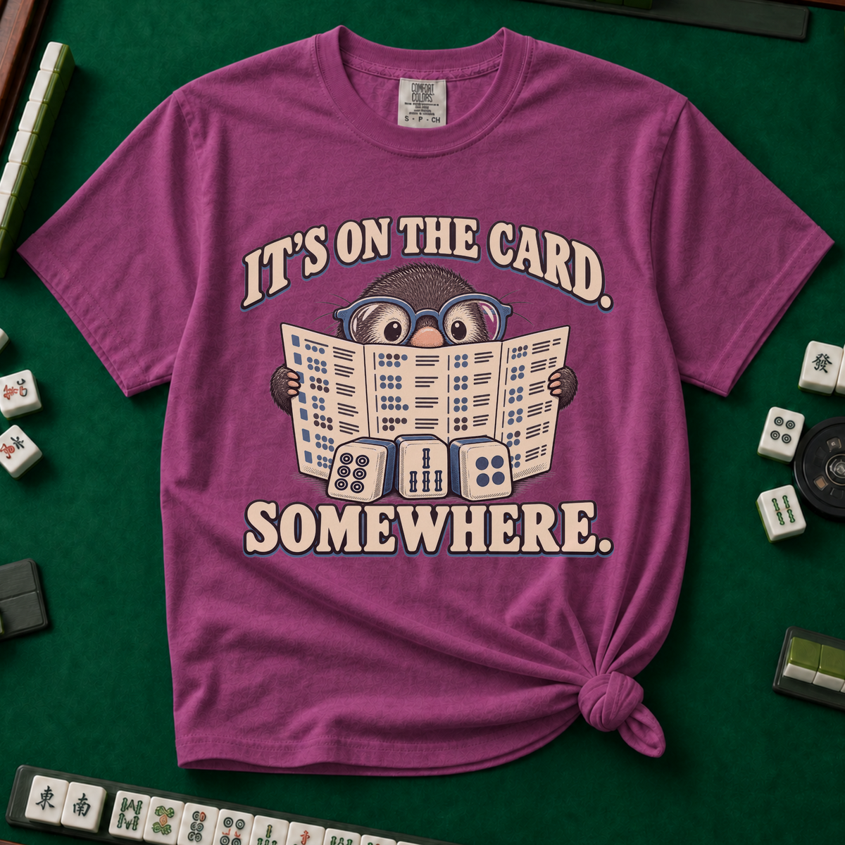 It's On The Card Somewhere mahjong shirt in Ivory — a wide-eyed mole in oversized glasses peeking over the open mahjong card, three tiles below, with the words IT'S ON THE CARD. SOMEWHERE.