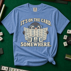 It's On The Card Somewhere mahjong shirt in White — a wide-eyed mole in oversized glasses peeking over the open mahjong card, three tiles below, with the words IT'S ON THE CARD. SOMEWHERE.