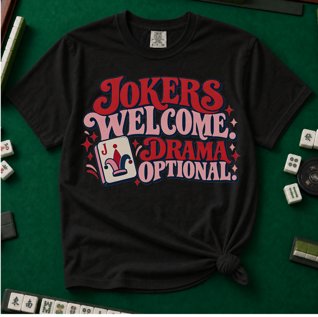 Jokers Welcome Drama Optional T-Shirt in Blossom - knotted tee on a pink surface with mahjong tiles scattered around, printed with the words Jokers Welcome Drama Optional in retro bubble lettering with a joker tile