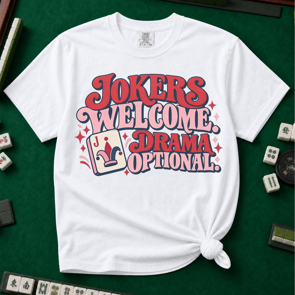 Jokers Welcome Drama Optional T-Shirt in Black - knotted tee on a light surface with mahjong tiles scattered around, printed with the words Jokers Welcome Drama Optional in retro bubble lettering with a joker tile