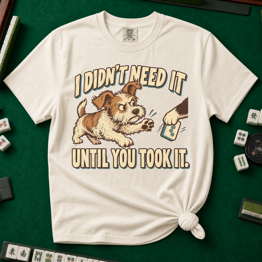 I Didn't Need It Until You Took It T-Shirt in Blossom - knotted tee on a pink surface with mahjong tiles scattered around, printed with a scruffy puppy lunging for a tile as another paw takes it away, and the words I Didn't Need It Until You Took It