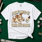I Didn't Need It Until You Took It T-Shirt in White - knotted tee on a green mahjong mat with scattered tiles, printed with a scruffy puppy lunging for a tile as another paw takes it away, and the words I Didn't Need It Until You Took It