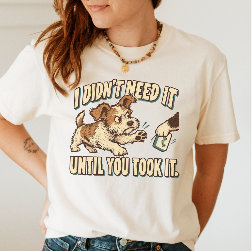 I Didn't Need It Until You Took It T-Shirt in Blue Jean - tee on a dark surface with mahjong tiles scattered around, printed with a scruffy puppy lunging for a tile as another paw takes it away, and the words I Didn't Need It Until You Took It