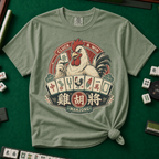 Cluck And Win Mahjong Rooster T-Shirt in Moss - knotted tee on a green mahjong mat with scattered tiles, printed with a rooster holding a green dragon tile above a fan of mahjong tiles in a red Cluck and Win badge