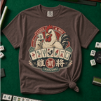 Cluck And Win Mahjong Rooster T-Shirt in Espresso - knotted tee on a green mahjong mat with scattered tiles, printed with a rooster holding a green dragon tile above a fan of mahjong tiles in a red Cluck and Win badge