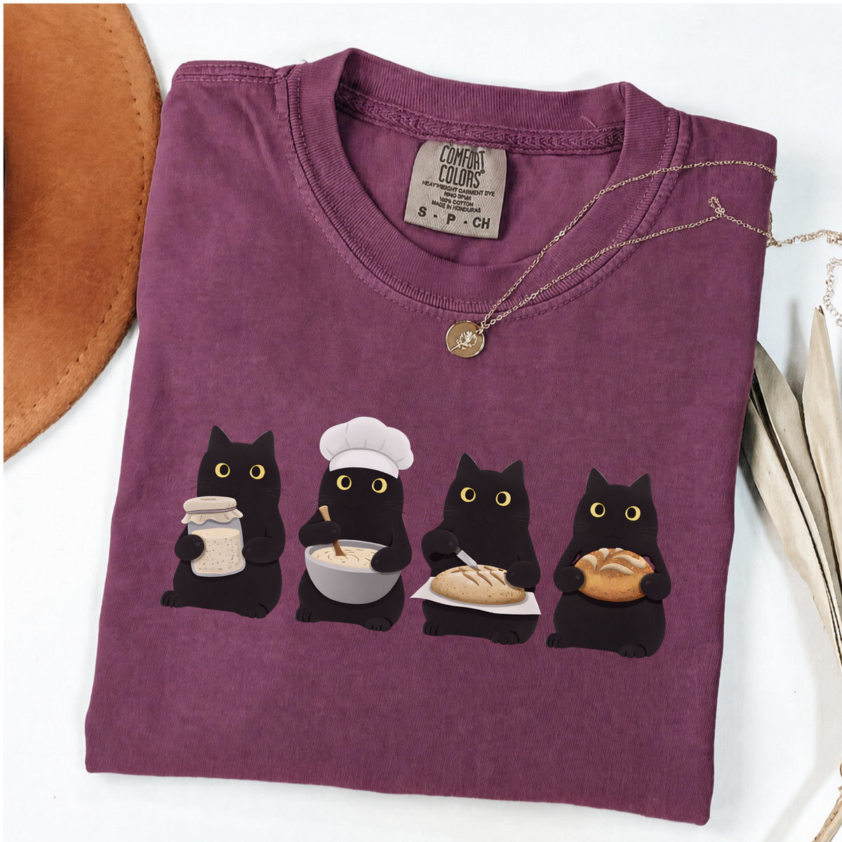 Four black cats making sourdough from starter to finished loaf on an Berry Comfort Colors T-shirt.