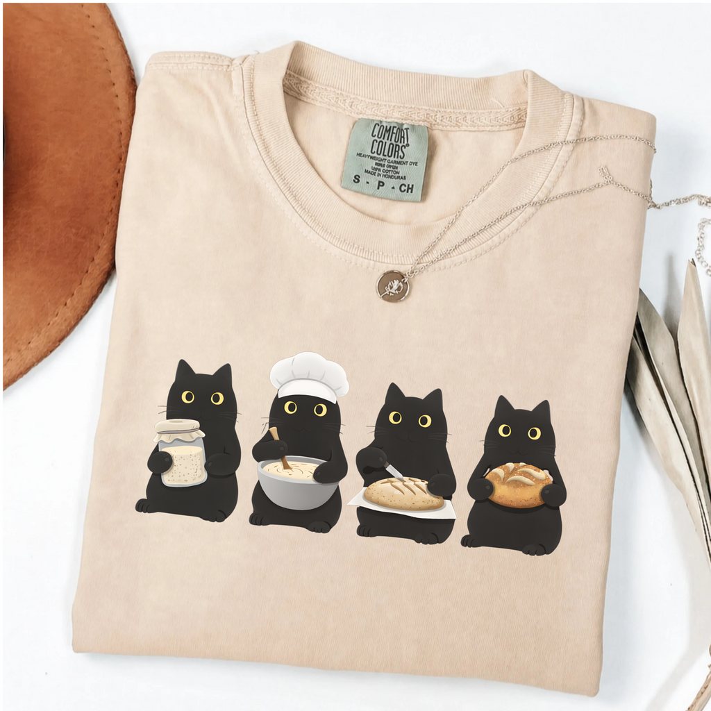 Four black cats making sourdough from starter to finished loaf on an Ivory Comfort Colors T-shirt.