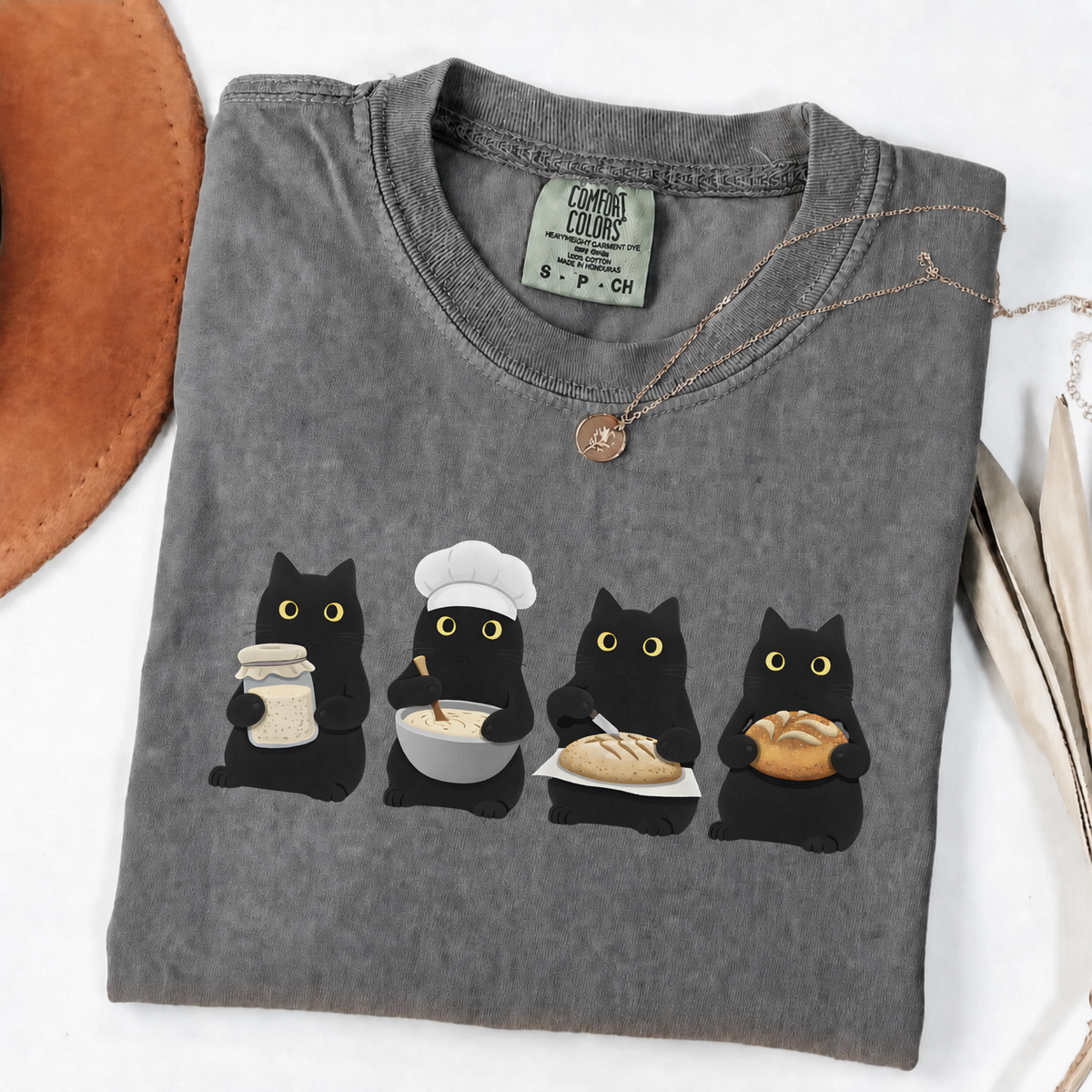 Four black cats making sourdough from starter to finished loaf on an Pepper  Comfort Colors T-shirt.