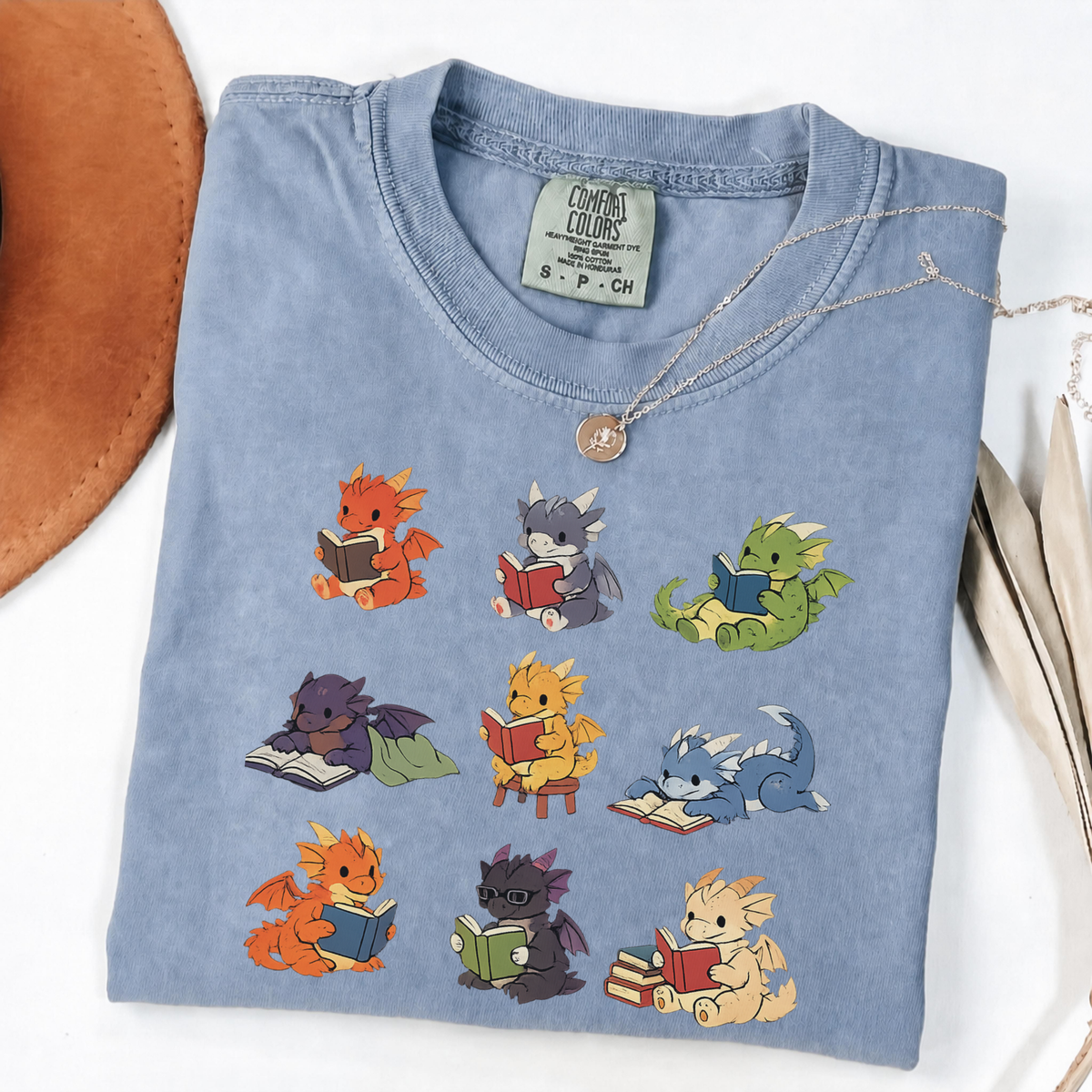 Nine colourful bookish dragons reading on an Blue Jean Comfort Colors T-shirt