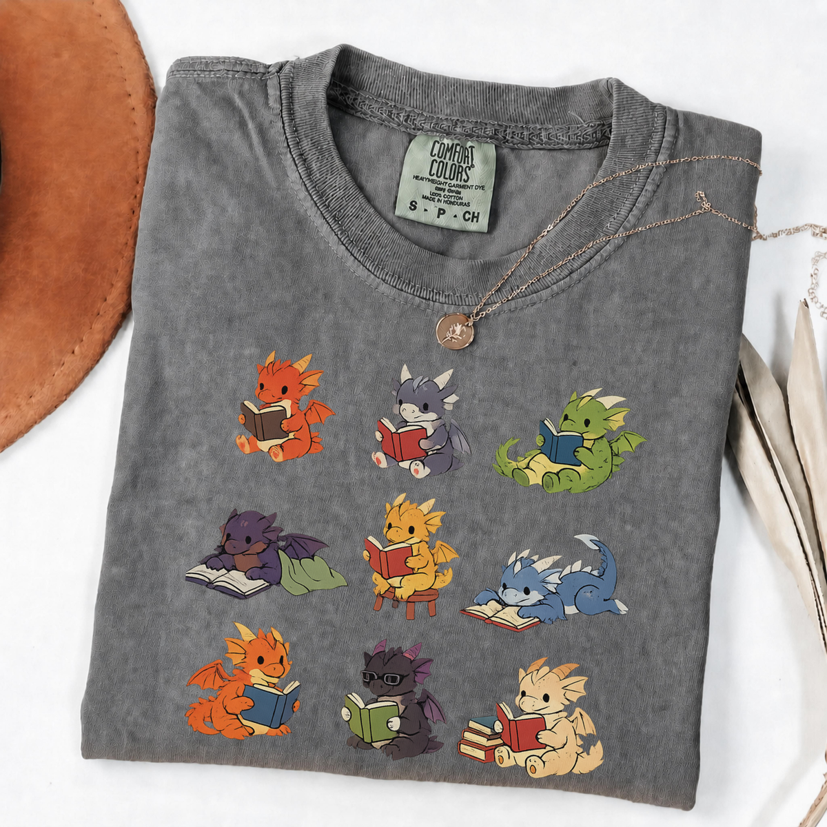 Nine colourful bookish dragons reading on an Pepper Comfort Colors T-shirt