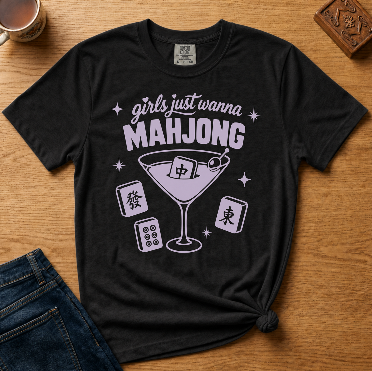 Girls Just Wanna Mahjong Shirt in Espresso - pink lettering and a martini glass with a mahjong tile on a folded brown Comfort Colors 1717 tee, styled flat lay