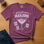 Girls Just Wanna Mahjong Shirt in Berry - pink lettering and a martini glass with a mahjong tile on a folded berry Comfort Colors 1717 tee, styled flat lay