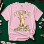 Ask Me After The Charleston T-Shirt in Blossom, knotted flat lay on a green mahjong mat - shrugging meerkat standing beside three mahjong tiles - "ASK ME AFTER THE CHARLESTON." in cream collegiate letters