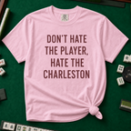 Don't Hate The Player Hate The Charleston T-Shirt in Blossom, knotted flat lay on a green mahjong mat - "DON'T HATE THE PLAYER, HATE THE CHARLESTON" in deep burgundy block letters