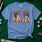 I Threw It Then I Needed It T-Shirt in Blue Jean, knotted flat lay on a green mahjong mat - a retro comic two-panel scene of a woman smugly flicking away a mahjong tile, then panicking when she needs it, with the words "I THREW IT. THEN I NEEDED IT."