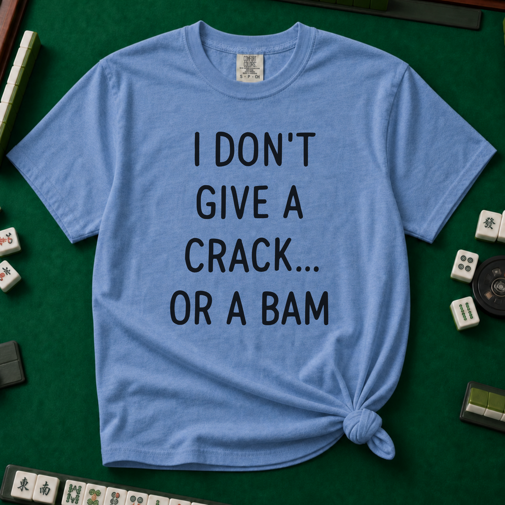 I Don't Give A Crack Or A Bam T-Shirt in Blue Jean, knotted flat lay on a green mahjong mat - "I DON'T GIVE A CRACK... OR A BAM" in black handwritten-style letters