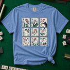 Mahjong Chicken Tiles T-Shirt in Blue Jean, knotted flat lay on a green mahjong mat - a 3x3 grid of mahjong tiles, each starring a cartoon chicken with its own personality - varsity jacket, karate gi, cape, beanie, headphones, bookworm glasses, cherry blossom, pool floatie and skateboard