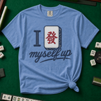 I Set Myself Up T-Shirt in Blue Jean, knotted flat lay on a green mahjong mat - a stitched-look varsity rebus - a navy letter I beside a cream fa dragon tile with the red character, over "myself up" in navy script